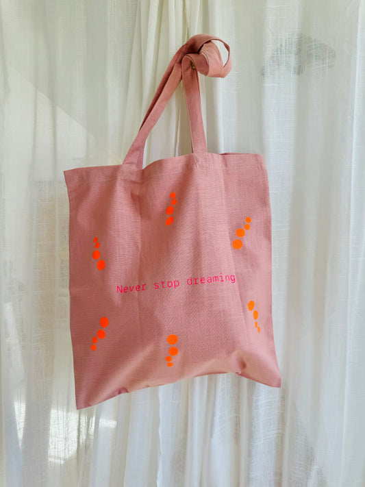 Støvet rosa mulepose med neon pink og orange print.